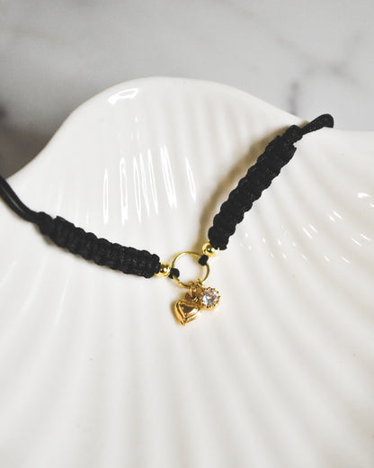 Pulsera amuleto ajustable hilo negro con punto de luz y mini corazón bañados en oro