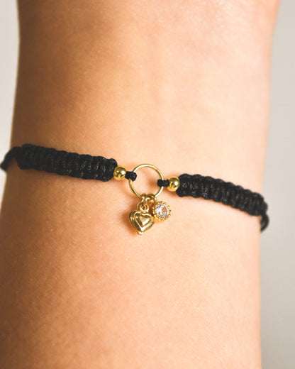 Pulsera amuleto ajustable hilo negro con punto de luz y mini corazón bañados en oro